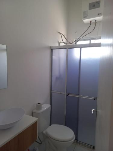 a bathroom with a toilet and a sink at Hotel Status in Jaguarão
