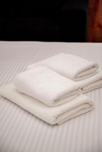 a pile of white towels sitting on a bed at Hotel Porto A in Ulcinj