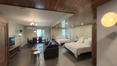 a bedroom with two beds and a living room at Motel Le Martinet in La Pocatiere