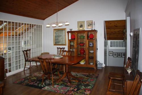 - une salle à manger avec une table et des chaises en bois dans l'établissement 2 Moon Cottage, à Niagara on the Lake