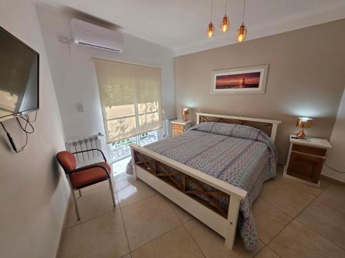 a bedroom with a bed and a tv and a window at Departamentos Atlantic in Monte Hermoso
