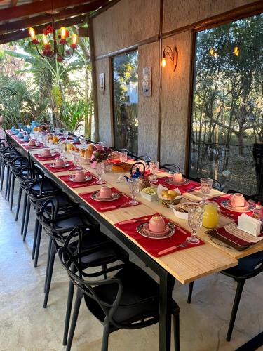 a long table with plates and bowls on it at Portal Das Fadas - Hospedagem in Cavalcante
