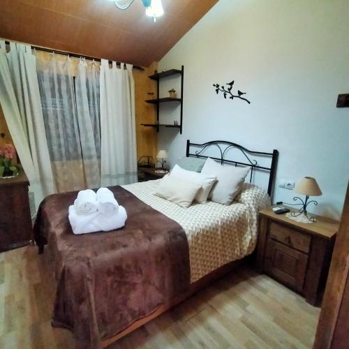 a bedroom with a bed with two towels on it at Alborada in Pinos Genil