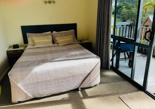 a bedroom with a bed and a balcony at Alba Pacis in Paihia