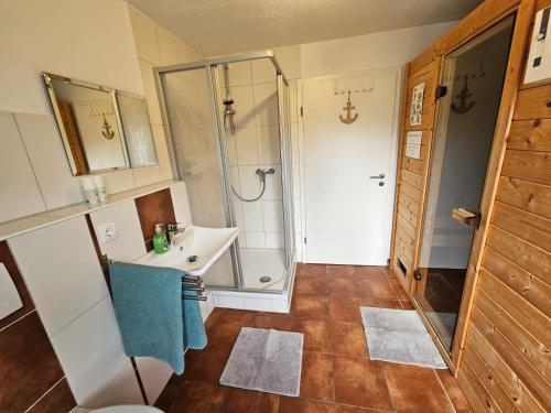 a bathroom with a sink and a shower at Ferienhaus Seeschwalbe in Tossens