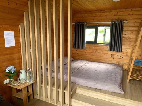 a bedroom with a bed in a wooden cabin at Lang Omm in Tang Klang