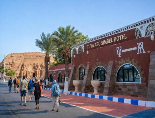 a group of people walking in front of a building at Tuya Abu Simbel Hotel in Abu Simbel