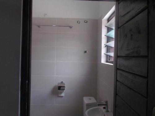 a bathroom with a toilet and a sink at Rams Lodge in Accra