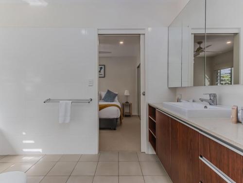 a white bathroom with a sink and a bed at Macadamia Ocean Escape in Pottsville