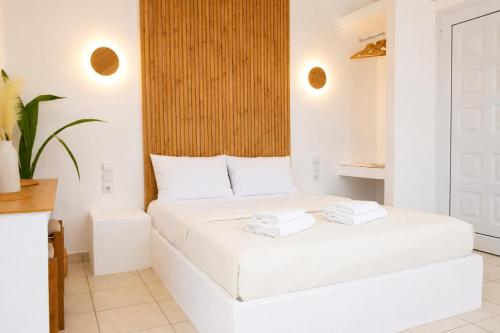 a bedroom with a white bed with towels on it at Elichri Theros Studios in Katelios
