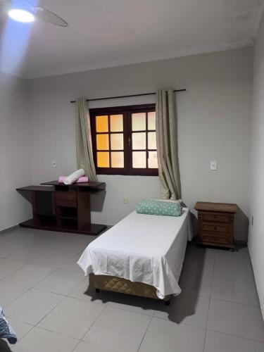 a bedroom with a bed and a desk and a window at Quarto privativo com suite para 1 pessoa in Campinas