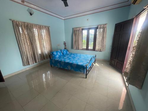 a bedroom with a bed in a room with blue walls at D Cunhas Riviera in Cochin