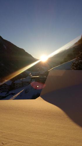 a sand dune with the sun setting in the background at Ferienhaus Nadine in Kappl