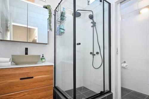 a bathroom with a glass shower with a sink at Beachfront 1BR Loft. Surf-Café-Unwind in Marcoola