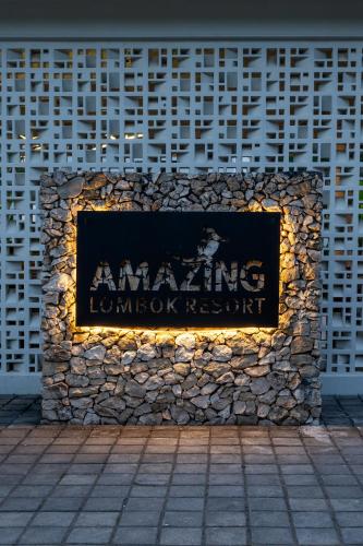 a sign on the side of a stone wall at Amazing Lombok Resort in Selong Belanak