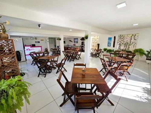 a dining room with wooden tables and chairs at Pousada Sol Nascente in Guaibim