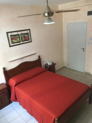 a bedroom with a bed with a red bedspread at Hotel El Porteño in Buenos Aires