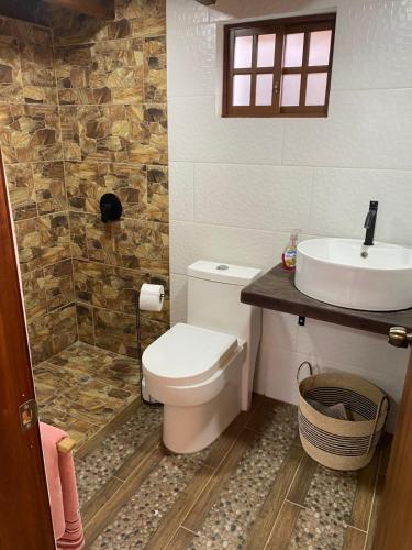 a bathroom with a toilet and a sink at Cabañas San Carlos - Puembo Centro in Puembo
