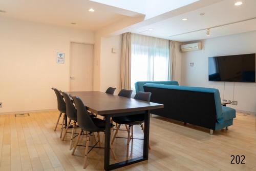 a conference room with a table and chairs and a tv at Shibuya City House 渋谷シティハウス in Tokyo