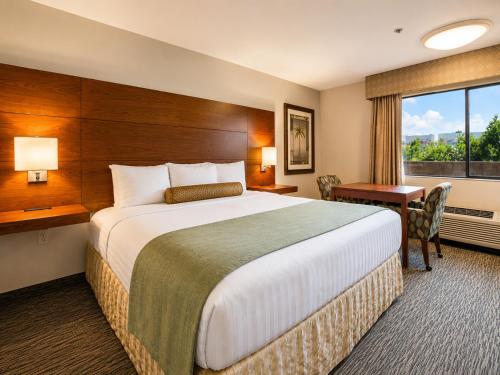 a hotel room with a bed and a desk and a window at Yuma Inn & Suites in Yuma