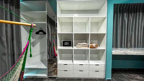 a closet with white shelves and a baseball bat at Kaan Serenity Sanctuary in Coba
