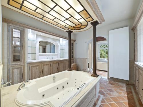 a large bathroom with a large tub and a large window at Luxury Country House with Pool in Manhay