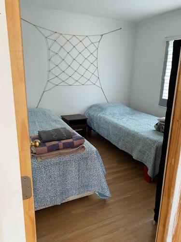 a bedroom with two beds and a door open at Cabañas CR guanaqueros in Coquimbo