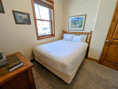 a small bedroom with a bed and a window at Antlers Gulch 501 by SummitCove Lodging in Colorado in Keystone