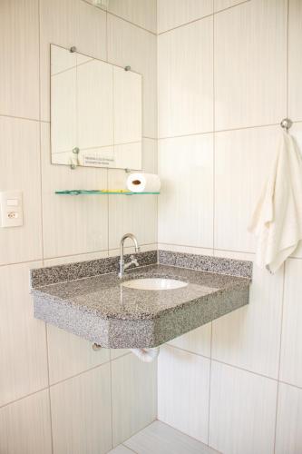 a bathroom with a sink and a mirror at Pousada Refúgio Serrano in Serra Negra