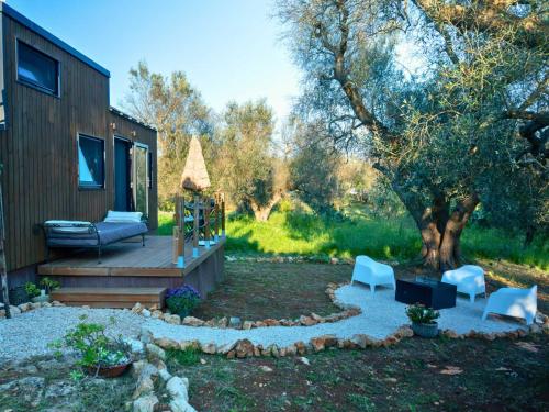 a backyard with a deck with a couch and chairs at Il Nostro Sogno - Madonna by Tiny Away in San Michele Salentino