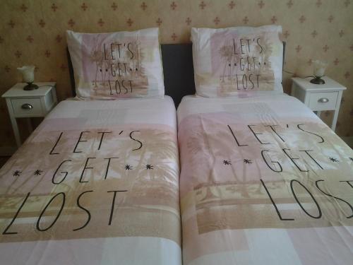 two beds with the words let s get lost at Bed & Breakfast Meinsma in Moddergat
