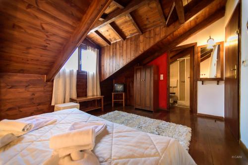 a bedroom with a large bed in a wooden building at Guesthouse Mavrodimos in Eptalofos
