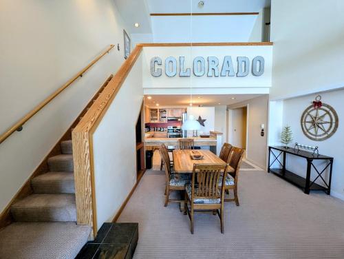 a restaurant with a table and chairs and a staircase at Pines 2129 by SummitCove Lodging in Colorado in Keystone
