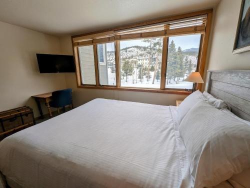 a bedroom with a large white bed and a window at Pines 2167 by SummitCove Lodging in Colorado in Keystone