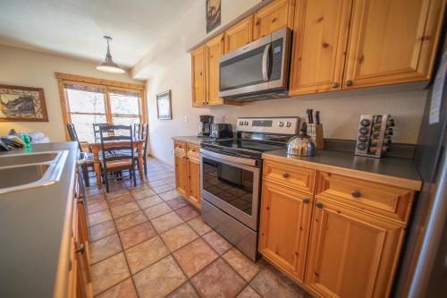 a kitchen with a stove and a microwave at Tenderfoot Lodge 2620 by SummitCove Lodging in Colorado in Keystone