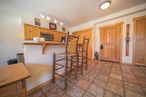 a kitchen with wooden cabinets and a counter with stools at Tenderfoot Lodge 2620 by SummitCove Lodging in Colorado in Keystone