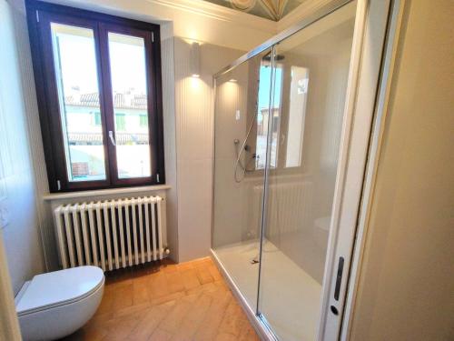a bathroom with a shower and a toilet and a window at Apartment Monsignore, Pesaro in Pesaro