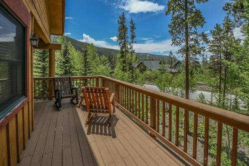 a deck with a bench and a view of a lake at Trappers Crossing 8753 by SummitCove Lodging in Colorado in Keystone