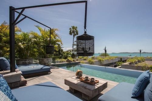 a villa with a swimming pool and a patio at Clay Beach Samui - Beachfront Villas in Bophut