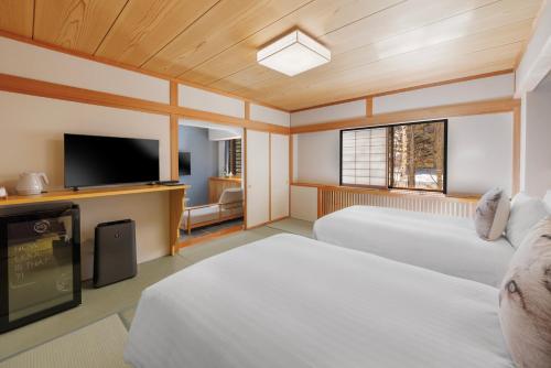 a room with two beds and a flat screen tv at Club Wyndham Shirakabaso Shigakogen in Yamanouchi