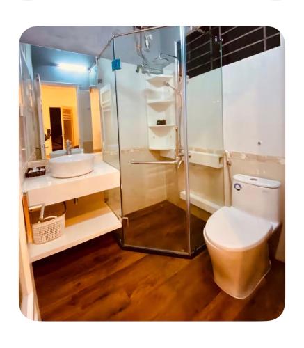 a bathroom with a toilet and a glass shower at Rose's House Hue in Hue