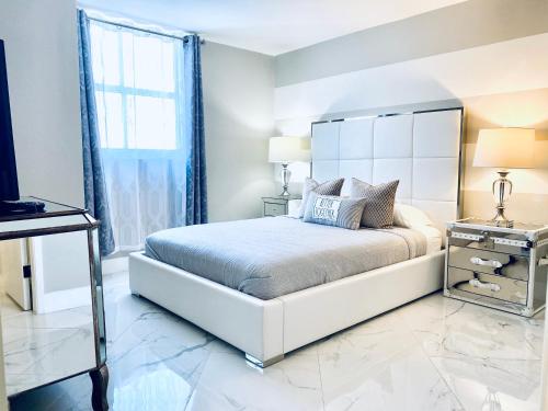 a white bedroom with a large bed and a window at Ocean & Bay Views 2BR 2BA Beach Condo! Parking in Miami Beach