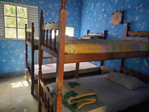 two bunk beds in a room with blue walls at Vila Druida Spa Caipira in São Thomé das Letras