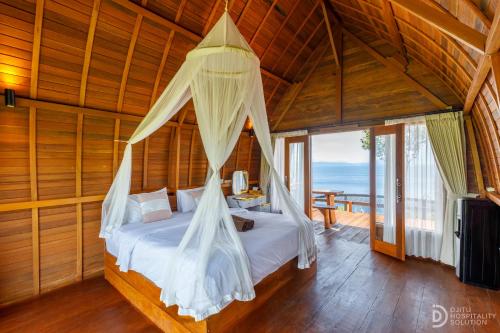 a bedroom with a bed with mosquito net at Eco-tourist Dream Beach Cliff Villas in Nusa Penida
