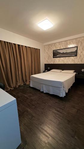 a bedroom with a large bed in a room at Flat Suites Pampulha - AP 122 - Particular in Belo Horizonte