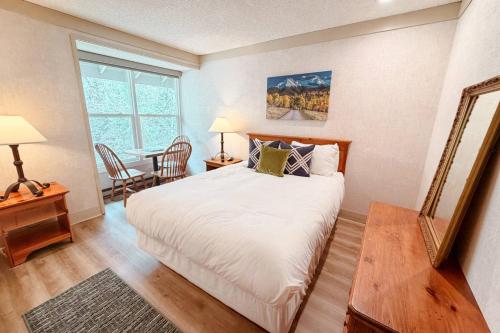 a bedroom with a large bed and a table at So Davis St 333 Unit #414 ~ Mountaineer in Telluride