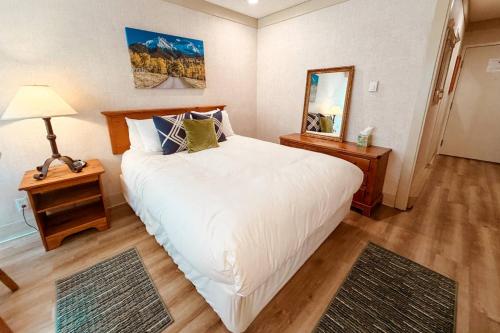 a bedroom with a large white bed and a mirror at So Davis St 333 Unit #414 ~ Mountaineer in Telluride