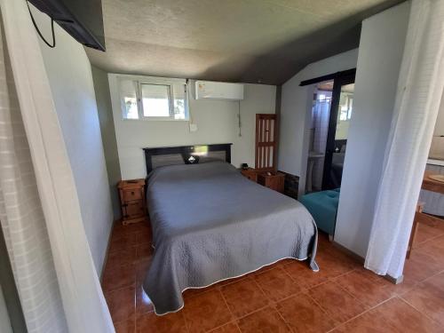 a bedroom with a bed in the corner of a room at Hospedaje El Rancho in Castillos