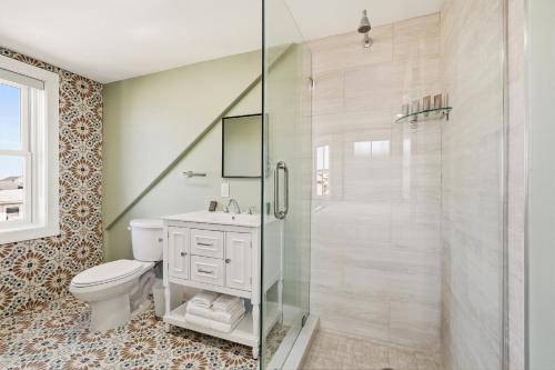 a bathroom with a toilet and a glass shower at The Marilyn Inn in Ocean Grove
