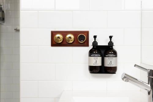 two bottles of wine sitting on a wall in a bathroom at The Corner Hotel Alexandra in Alexandra